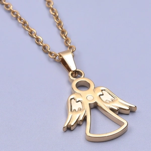 Macro detail of 18k gold plated angel pendant with polished wing texture on purple fabric