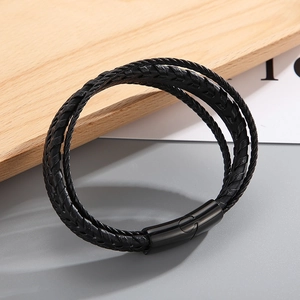 Macro shot of multi-layer black braided leather bracelet with magnetic steel clasp