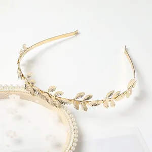 Detailed view of elegant golden leaf headband featuring intricate metallic leaf texture