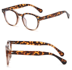Détails de montures de lunettes rondes en écaille avec rivets flèche argentés sur les branches