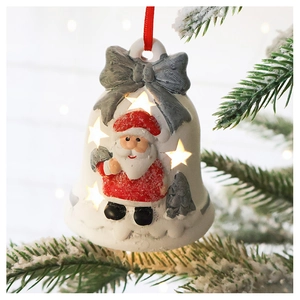 Macro shot of illuminated white Christmas bell ornament with Santa Claus and star cutouts