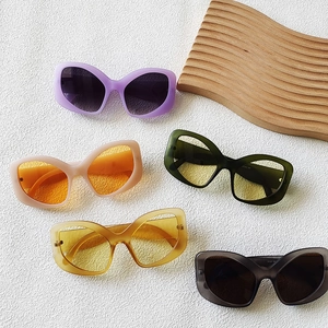 Chic cat eye sunglasses set in various colors on a textured stone background