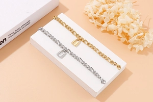 Makroansicht goldener und silberner Vorhängeschloss-Armbänder auf einem Podest
