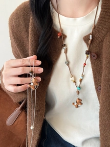 Detail of wooden pony pendant necklace with colorful beads and braided leather cord