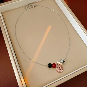 Bohemian titanium steel necklace with spotted stone beads and button pendant detail