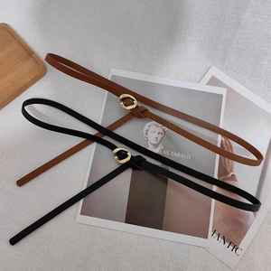 Detail of slim black and brown leather waist belts with irregular gold metal rings