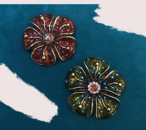 Detailed macro view of vintage flower brooches in red-brown and dark green with crystals