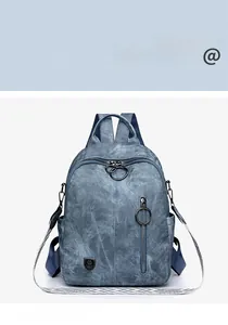 Detail of blue denim textured backpack showing vintage round ring zipper and logo