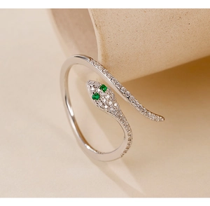 Macro shot of snake ring with green zircon eyes and white crystal inlay on silver