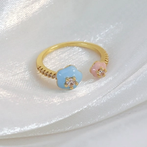 Detailed close-up of gold open ring with colorful flowers and shimmering zircon crystals