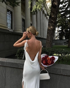 Détail d'une robe en satin blanc avec dos nu et fines chaînes dorées élégantes