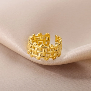 Detailed macro view of 18k gold plated braided open ring on champagne silk fabric