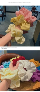 Detail of colorful oversized chiffon scrunchies stacked and worn on wrist for styling