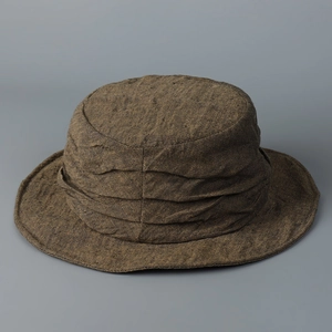 Close-up of vintage brown linen bucket hat showing textured fabric and stylish fold detail