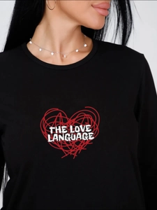 Close-up of heart print and 'THE LOVE LANGUAGE' text on black long-sleeve pajama top