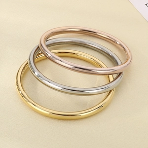 Close-up of polished 18k gold silver and rose gold stackable stainless steel bangles