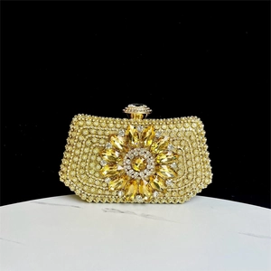 Detailed close-up of golden evening clutch with crystal rhinestones and flower motif