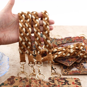 Close-up of bohemian cork card holder with braided wristlet and gold lobster clasp