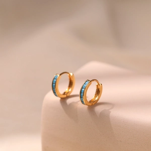 Detail view of 18K gold plated hoop earrings with turquoise rectangular zircons