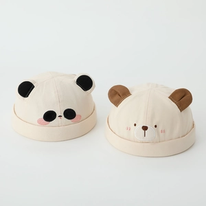 Detail of baby hats featuring cute embroidered panda and brown bear animal designs