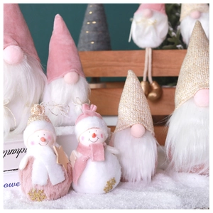 Group of plush Christmas gnomes and pink snowmen on a winter-themed decorative shelf