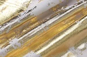 Detail of white fabric with metallic gold foil abstract print and soft draped texture