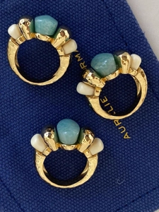 Detail of three vintage gold rings with amazonite stones and hammered metal texture