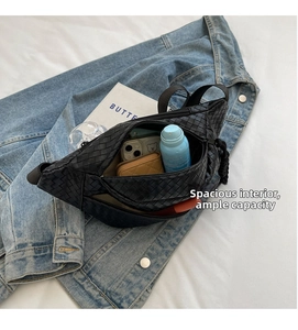 Internal view of black woven sling bag showing large capacity for phone and wallet