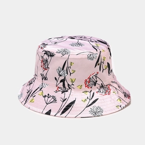 Dettaglio di un cappello da pescatore rosa con motivi floreali neri e accenti colorati