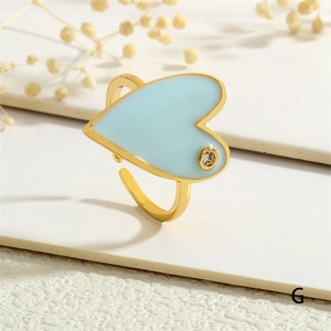 Detailed view of light blue enamel heart ring with gold band and single cubic zirconia