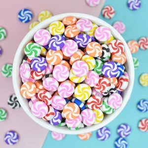 Overhead view of colorful swirl candy charms in a white bowl for DIY crafts and decor