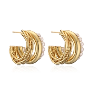 Detail view of gold-plated twisted C-shaped earrings accented with five white pearls