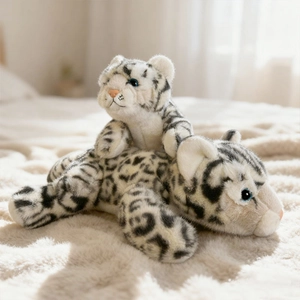 Adorable plush snow leopard stuffed animal pair on soft carpet in a cozy room
