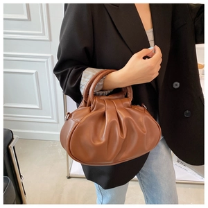 Brown pleated cloud handbag featuring circular handles and a detachable shoulder strap detail