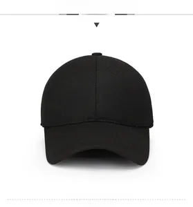 Detail of a black wool baseball cap featuring a metal logo plaque and twill texture