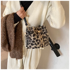 Detail of leopard print plush bucket bag with pearl drawstring and leather strap