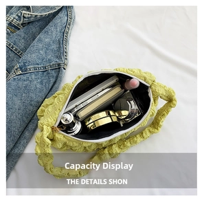 Interior view of yellow pleated cloud bag showing capacity for phone and cosmetics