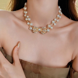 Vintage double layer pearl necklace featuring a luxury rhinestone bow pendant on model