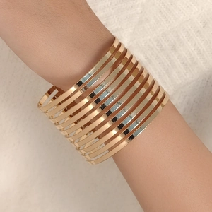 Gros plan d'un bracelet manchette spirale doré multicouche élégant pour femme