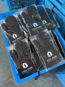 Detail of heat-resistant black silicone oven mitts with non-slip texture and logo