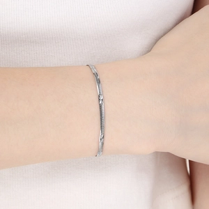 Detailed view of silver stainless steel flat snake chain bracelet on person's wrist