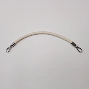 Detail view of a cream leather handbag handle with metallic silver carabiner hooks