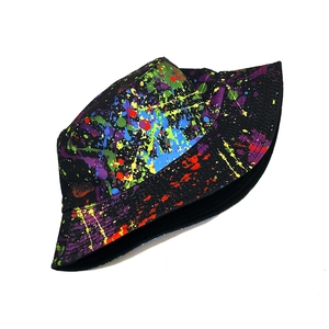 Detail of street style bucket hat featuring vibrant colorful paint splatter pattern