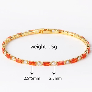 Detail eines Goldarmbands mit orangen Baguette-Steinen und weißen Diamanten aus der Nähe