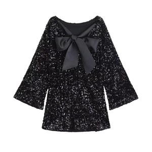 Detailed view of black sequined dress featuring a large silk-texture bow decoration