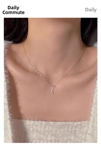 Close-up of minimalist rose gold moon necklace with sparkling diamonds on a model