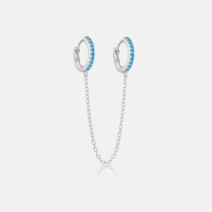 Detail of s925 silver double piercing earrings with chain and blue beads on white back