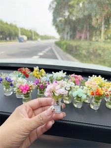 Close-up of mini artificial flower bouquet in a glass bottle with Good Luck label