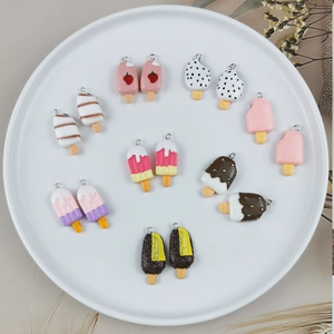 DIY colorful resin ice cream pendant set with metal loops on a white ceramic plate