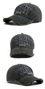 Dettaglio del ricamo vintage e del bordo consumato su questo cappellino da baseball grigio